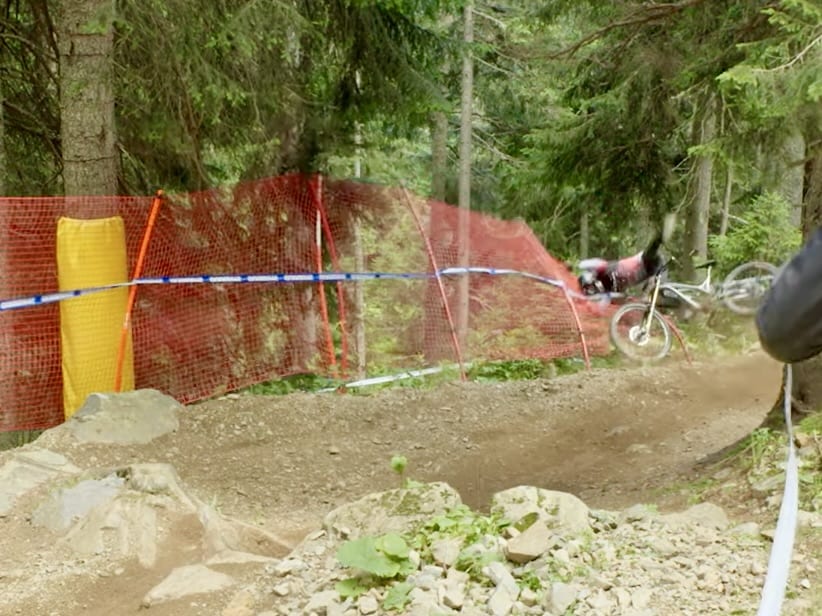 mountain biker crashing through a safety fence during a race
